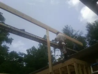 Carpenter setting a ridge beam over a new addition frame — Ice Dam Removal by Roofing Brothers in New Virginia