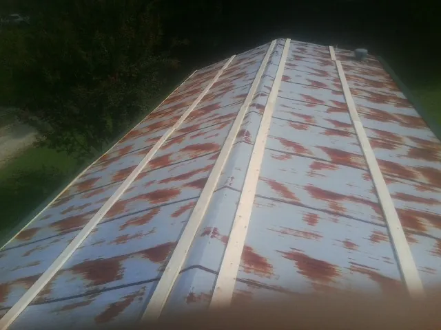 Rusted metal roof panels with new wood purlins before replacement — Storm Damage Roof Repair in New Virginia by Roofing Brothers