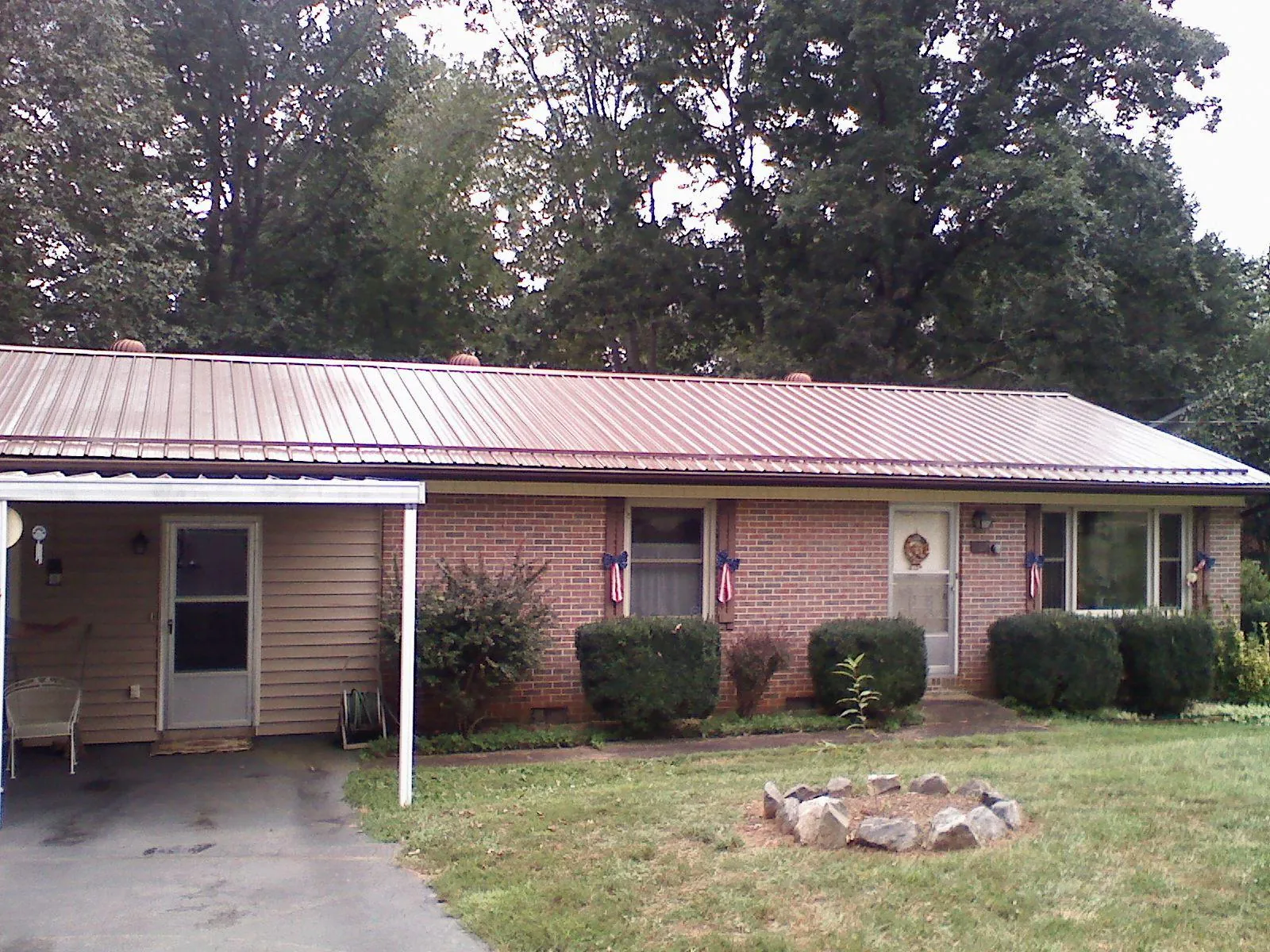 Bronze metal roof and carport on a brick ranch home — Roof Repair work by our crew in New Virginia